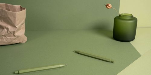 Kuvassa on asetelma, jossa on maljakko sekä kaksi kynää.